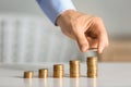 Man stacking coins on table. Savings concept