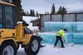 Man stacks cut ice block to build the Ice hotel in JukkasjÃ¤rvi in Sweden with a loader