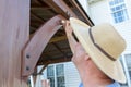 Man staining a wooden beam on an outdoor gazebo
