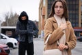 Man stalking young woman on city street Royalty Free Stock Photo