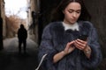 Man stalking young woman with phone in alley Royalty Free Stock Photo