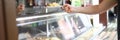 Man stand behind counter of ready-made food in dining room and hold plate with lunch in his hand. Royalty Free Stock Photo