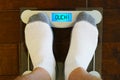 Man stand on the digital weight scale with humorous OUCH message.