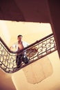 Man stand high on staircase. Businessman climb stairs. Sexy macho in open shirt with bare torso on stairway. Success in