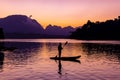 Man stand paddling on his kayak at Ratchaprapa dam, or known as Cheow Lan dam, during sunrise Royalty Free Stock Photo