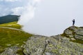 The man stand on top surrounded by fog and low clouds near Transalpina road in Romania Royalty Free Stock Photo