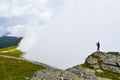 The man stand on top surrounded by fog and low clouds near Transalpina road in Romania Royalty Free Stock Photo