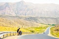 Man stand by touring bicycle in mountains on side of road pack have break time rest. Solo travel journey with bicycle bags. Long- Royalty Free Stock Photo