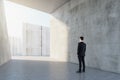 Man standing in abstract concrete tile space interior background with sunlght. Design concept Royalty Free Stock Photo