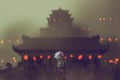 Man standing against ancient temple with red lights