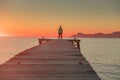 Man standing alone on the pier. Summer sunset sky in background