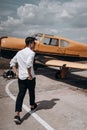 A man standing on the background of a small single engine plane. Royalty Free Stock Photo