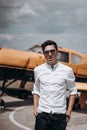 A man standing on the background of a small single engine plane. Royalty Free Stock Photo