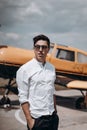 A man standing on the background of a small single engine plane. Royalty Free Stock Photo