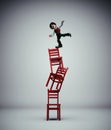 Man standing in balance on a stack of chairs Royalty Free Stock Photo