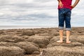 Man standing barefoot on the beach of stones on the seashore