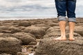 Man standing barefoot on the beach of stones on the seashore Royalty Free Stock Photo