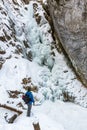 The man standing at the base of the frozen waterfall