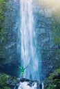 Man standing at base of massive waterfall Royalty Free Stock Photo