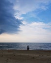Man standing on beach against storm cloud