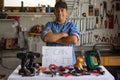 Man standing behind a table with drills on it with a writing "I can fix it" Royalty Free Stock Photo