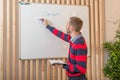 Man standing by the blackboard writes a task for class work Royalty Free Stock Photo
