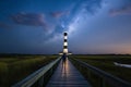 Man Standing On A Boardwalk At Bodie Island Lighthouse Under The Night Sky