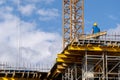 Man standing on building with iron elements and looking surveyor