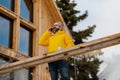 Man standing on cabins patio, drinking hot tea, coffee and enjoying beautiful winter day. Handsome man spending relaxing Royalty Free Stock Photo