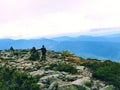 A man standing by cairn marker on Mt. Washington