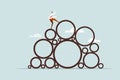 A businessman climbing on top of a heap of circles with difficulty