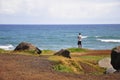 Man standing at cliff at Mokuleia Beach Park, Kaena Point at the North Shore on Oahu Island, Hawaii, United States