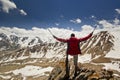 Man standing on a cliff in mountains with poles