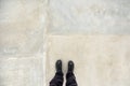 Man standing on concrete flooring surface, feet from above