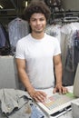 Man Standing At Counter In Dry Cleaning Store