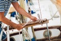 Man standing on the deck of his boat using a winch while out for a sail on a sunny afternoon Royalty Free Stock Photo