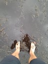 Man standing in dirty puddle during muddy weather Royalty Free Stock Photo