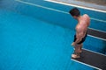 Man standing on diving board at public swimming pool Royalty Free Stock Photo