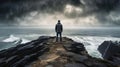 Man standing on the edge of a cliff in front of the ocean