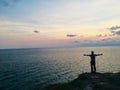 Man standing on the edge cliff and looking the sea