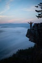 Man standing on the edge of the rock hanging above the scenery valley