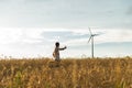 A man standing in a field looking at a wind generator Royalty Free Stock Photo