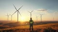 A man standing in a field with wind turbines in the background Royalty Free Stock Photo