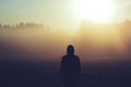 Man standing in the fog at sunrise Royalty Free Stock Photo