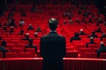 Man standing in front of audience in red seats Royalty Free Stock Photo