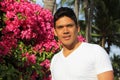 Man standing in front of Bougainvillea flowers