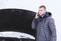 Man holding mobile phone and calling winter car services to help Royalty Free Stock Photo