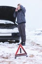 Man holding mobile phone and calling winter car services to help Royalty Free Stock Photo