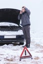 Man holding mobile phone and calling winter car services to help Royalty Free Stock Photo