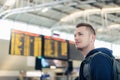 Man standing in front of flight information board inside airport terminal Royalty Free Stock Photo